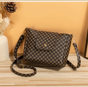 Detail of brown bucket bag with vintage geometric print and gold metal buckle