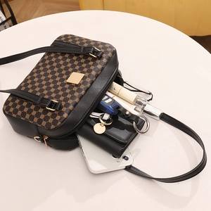 Borsa a tracolla retrò con stampa monogramma e cinturino in pelle su sfondo bianco