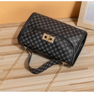 Detail of black embroidered crossbody bag with gold twist lock and accordion layers