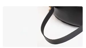 Detailed close-up of a black PU leather backpack handle with durable gold metal rings