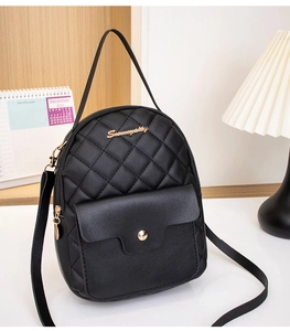Detail shot of black mini backpack featuring diamond quilting and gold logo finish