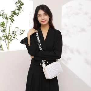 White rivet small square bag with wide branded strap worn on black suit outfit
