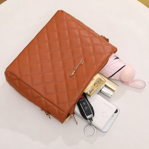 Brown quilted crossbody bag with wide strap showing interior storage for daily essentials