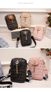 Détail du petit sac bandoulière avec logo couronne, pompon et sangle imprimée