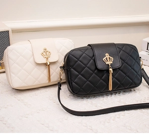 Detail of quilted crossbody bags with gold crown buckle and elegant metal tassels