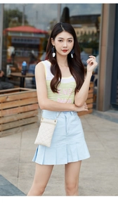 Quilted white chain phone bag worn by model with summer knitted top and denim skirt