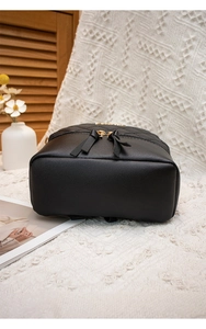 Détail du sac à dos en cuir matelassé noir avec fermetures éclair dorées et texture mate