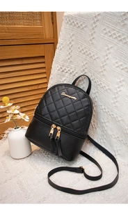 Détail du mini sac à dos noir matelassé avec logo doré et fermetures éclair à pompons