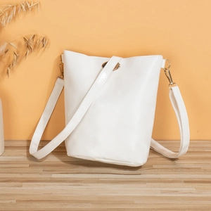 Elegant white bucket crossbody bag with gold hardware and minimalist clasp