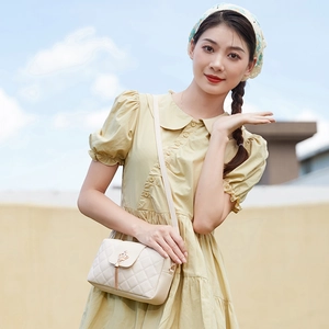 Women's cream quilted crossbody bag with golden crown hardware and tassel detail