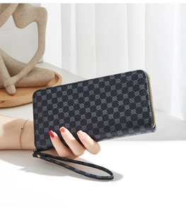 Detail of long floral zip wallet with gold hardware and wrist strap in lifestyle setting