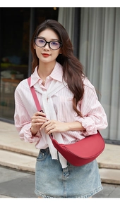 Outdoor shot of a stylish red half-moon crossbody bag in minimalist nylon fabric