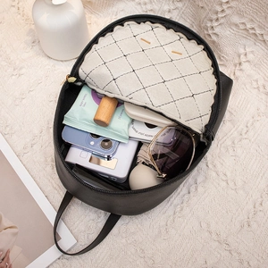 Mini sac à dos noir en cuir pour femme montrant l'espace de rangement et la capacité interne