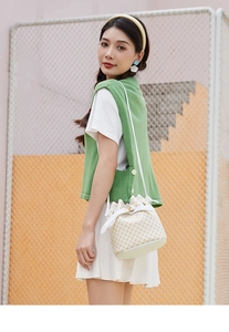 Détail du sac seau à motifs de losanges blancs et jaunes avec fermoir tournant en métal doré