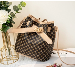Détail du sac seau vintage avec bordure contrastée, fermoir doré et motif circulaire