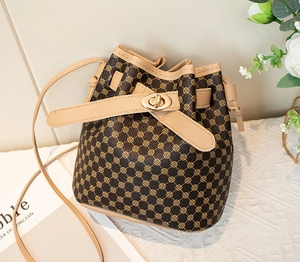 Détail du sac seau vintage avec imprimé monogramme et fermoir rotatif doré