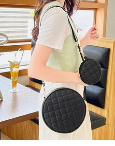 Vue détaillée du sac bandoulière rond matelassé noir avec petit porte-monnaie assorti
