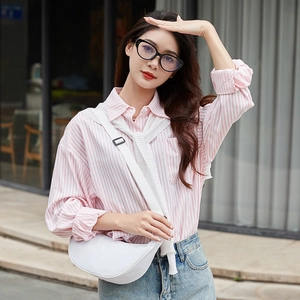 Minimalist white half-moon crossbody bag with adjustable strap worn by a female model