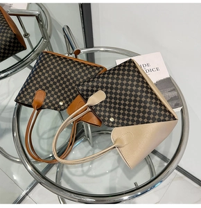 Dettaglio di borse tote vintage con stampe geometriche e rivetti dorati su tavolo in vetro