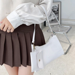 Stilvolle weiße Achseltasche mit Krokodilmuster und kleiner Tasche am Modell