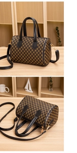 Detail of a brown cylinder Boston bag with yellow floral pattern and black leather handles