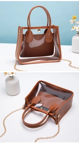 Dettaglio della borsa in PVC trasparente con finiture in pelle marrone e catena oro
