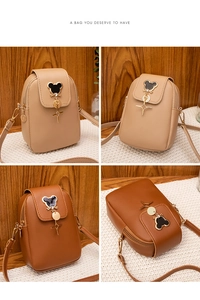 Detail of mini crossbody phone bag with cartoon character logo and star charms