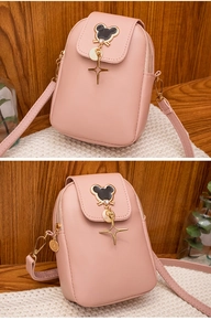 Macro detail of pink leather phone bag featuring a gold mouse silhouette charm and strap