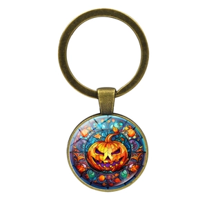 Macro view of bronze Halloween keychain with Gothic stained glass Jack-o'-lantern pendant
