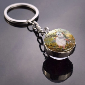 Macro view of hedgehog glass keychain reflecting on a dark glossy surface with sharp details