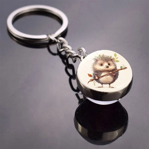 Detail of metal keychain with glass cabochon pendant featuring hedgehog illustration