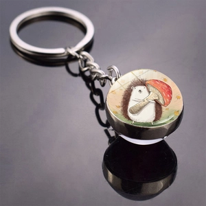 Macro detail of hedgehog and mushroom illustration under double-sided glass ball keychain