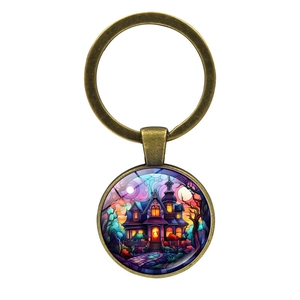 Vintage bronze keychain with round glass pendant featuring a colorful haunted castle illustration
