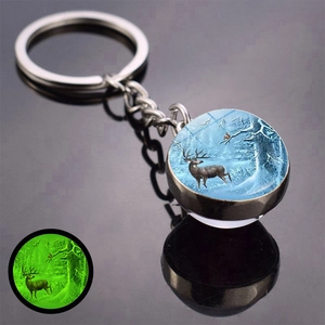 Close-up of luminous Christmas keychain with glowing forest deer pattern in the dark