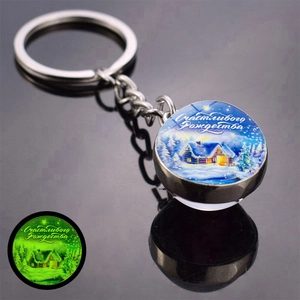 Luminous Christmas keychain featuring a snowy house scene and glowing green effect in dark
