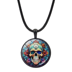 Macro view of bohemian round glass pendant with colorful mosaic skull and black cord