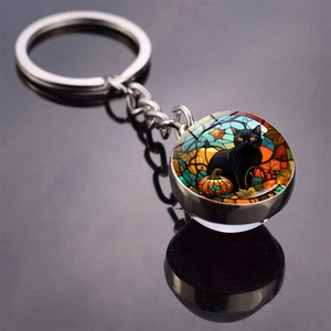 Detail of Halloween keychain with a black cat pumpkin glass ball and metal ring