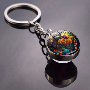 Close-up of Halloween pumpkin keychain with glass dome and double-sided forest illustration