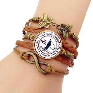 Macro detail of multi-layer woven leather bracelet with Pearl Harbor memorial pendant