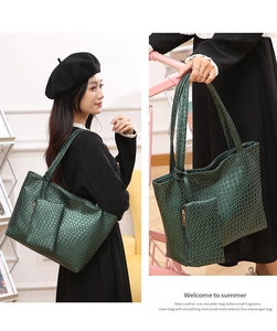 Detalle de bolso tote tejido verde oscuro con estuche de cremallera a juego y asas