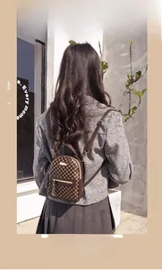Detail shot of mini brown backpack with circle pattern and golden metallic hardware