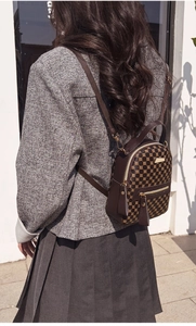 Outdoor shot showing back view of vintage brown printed backpack on female model