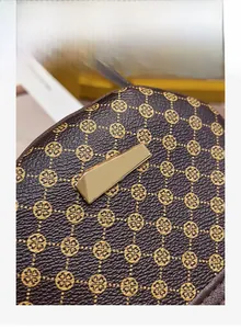 Close-up of pebble-textured leather brown crossbody bag with gold geometric metal plate