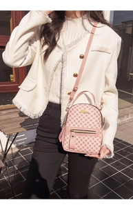 Detailed macro view of pink backpack featuring golden hardware and circular patterns