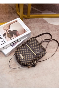 Detail of vintage brown leather mini backpack with gold ring prints and metal hardware