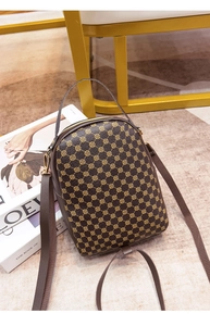 Detail view of a vintage brown crossbody bag with floral pattern and golden metal zippers