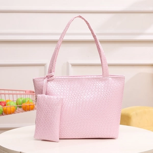 Conjunto de bolso tote tejido rosa con bolso de hombro y estuche en mesa blanca