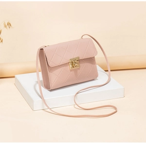 Detail of pink quilted shoulder bag with gold twist lock on a white display stand