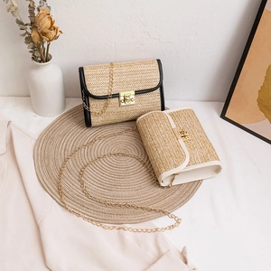 Women's woven straw crossbody bag with golden chain strap and buckle in chic vacation style