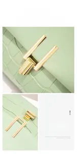 Detail of mint green crocodile embossed bag featuring a golden 360-degree rotating lock